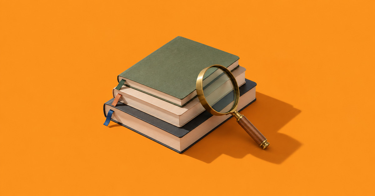 Tres libretas apiladas con separadores y una lupa de latón